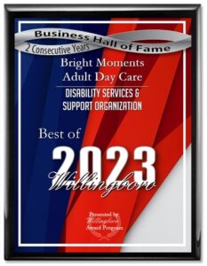 A framed award plaque displays "Business Hall of Fame," "2 Consecutive Years," and "Bright Moments Adult Day Care," a premier adult day care facility in Burlington County NJ. It recognizes "Best of 2023 Willingboro" for its exceptional disability services, presented by the Willingboro Award Program.